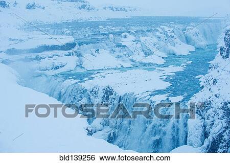 Stock Photograph - Snowy cliffs and waterfall, Gullfoss, Sudhurland, Iceland. Fotosearch