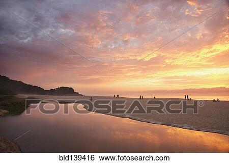 Stock Photograph - Sunset over still pool at beach. Fotosearch