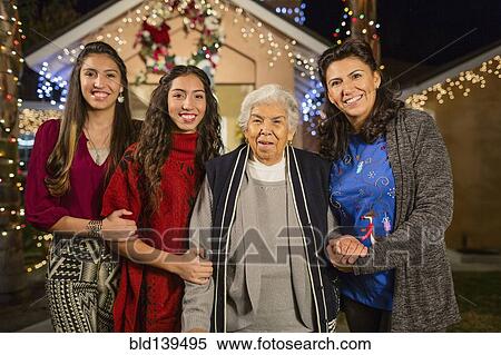 Three generations of Hispanic women smiling outside house decorated with string lights View Large Photo Image Stock Photography - Three generations of Hispanic women smiling outside house decorated with string lights. Fotosearch