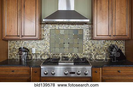 Tile back splash, ventilation hood and stove in kitchen View Large Photo Image Stock Photo - Tile back splash, ventilation hood and stove in kitchen. Fotosearch