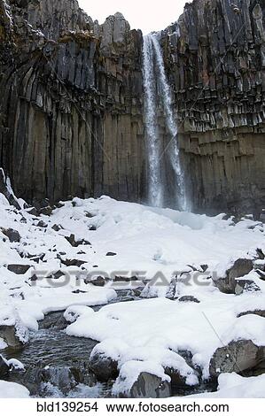 Waterfall and steep cliff in snowy landscape, Svartifoss, Sudhurland, Iceland View Large Photo Image Picture - Waterfall and steep cliff in snowy landscape, Svartifoss, Sudhurland, Iceland. Fotosearch