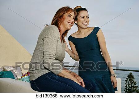 Stock Photo - Women relaxing together at waterfront. Fotosearch