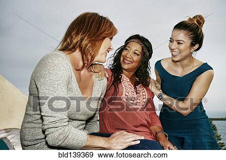 Women relaxing together at waterfront View Large Photo Image Stock Photo - Women relaxing together at waterfront. Fotosearch