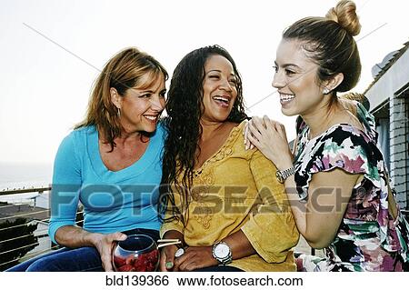 Women relaxing together at waterfront View Large Photo Image Stock Photograph - Women relaxing together at waterfront. Fotosearch