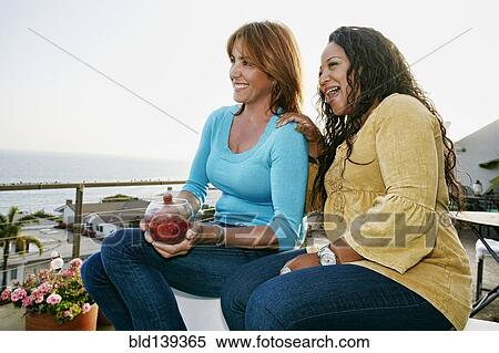 Women relaxing together at waterfront View Large Photo Image Stock Photography - Women relaxing together at waterfront. Fotosearch