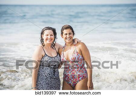 Women smiling together in ocean waves View Large Photo Image Stock Photo - Women smiling together in ocean waves. Fotosearch