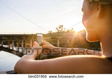 Caucasian teenage girl taking cell phone photograph of bridge View Large Photo Image Stock Photography - Caucasian teenage girl taking cell phone photograph of bridge. Fotosearch