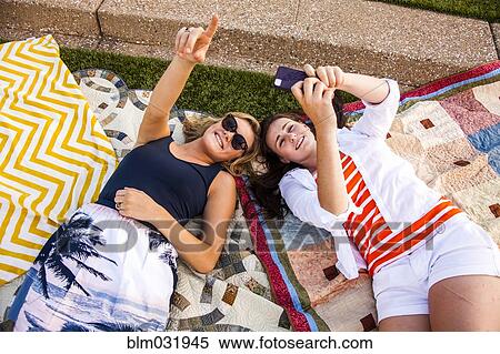 Caucasian teenage girls laying on picnic blankets in park View Large Photo Image Stock Photography - Caucasian teenage girls laying on picnic blankets in park. Fotosearch