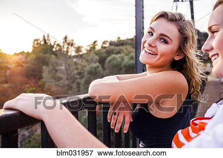 Stock Photo - Caucasian teenage girls standing on bridge. Fotosearch