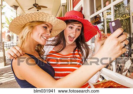 Caucasian teenage girls taking cell phone selfie in hats View Large Photo Image Stock Image - Caucasian teenage girls taking cell phone selfie in hats. Fotosearch