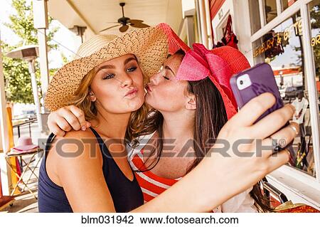 Caucasian teenage girls taking cell phone selfie in hats View Large Photo Image Stock Image - Caucasian teenage girls taking cell phone selfie in hats. Fotosearch