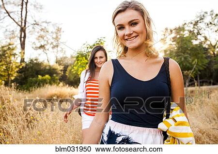 Caucasian teenage girls walking in tall grass in field View Large Photo Image Stock Image - Caucasian teenage girls walking in tall grass in field. Fotosearch