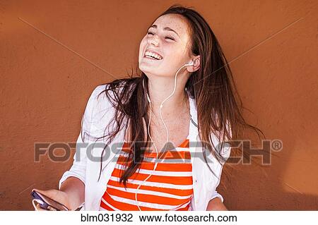 Caucasian woman listening to mp3 player View Large Photo Image Stock Image - Caucasian woman listening to mp3 player. Fotosearch