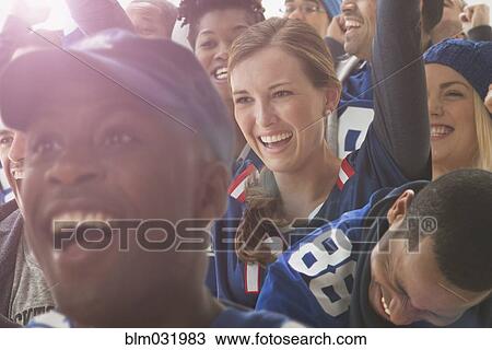 Stock Image - Fans cheering at American football game. Fotosearch