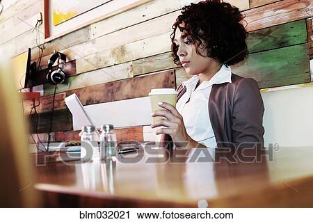 Mixed race businesswoman using laptop in cafe View Large Photo Image Stock Image - Mixed race businesswoman using laptop in cafe. Fotosearch