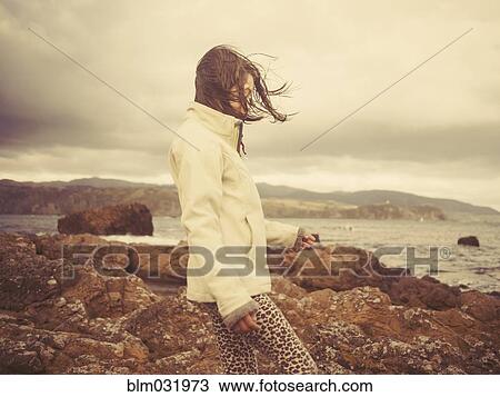 Mixed race girl walking on rocky beach View Large Photo Image Stock Image - Mixed race girl walking on rocky beach. Fotosearch