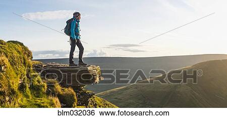 Stock Photograph - Panoramic view of hiker overlooking remote landscape. Fotosearch