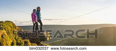 Stock Photo - Panoramic view of hikers overlooking remote landscape. Fotosearch