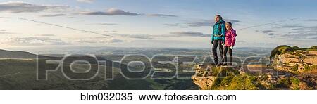 Stock Photography - Panoramic view of hikers overlooking remote landscape. Fotosearch