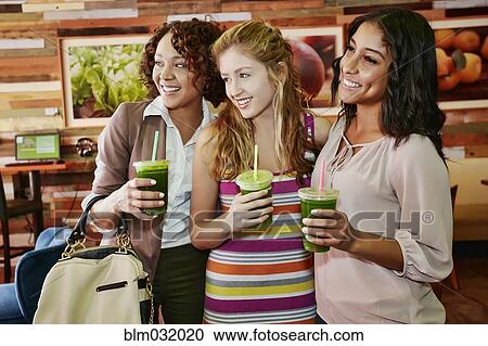 Women having juice together in cafe View Large Photo Image Stock Image - Women having juice together in cafe. Fotosearch