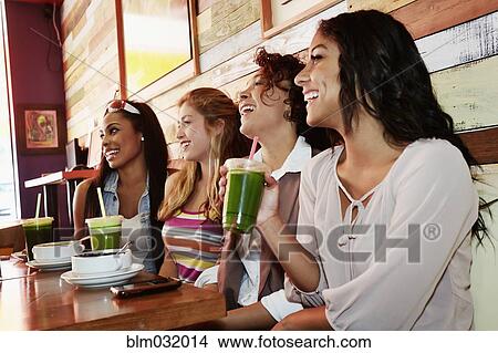 Picture - Women relaxing together in cafe. Fotosearch