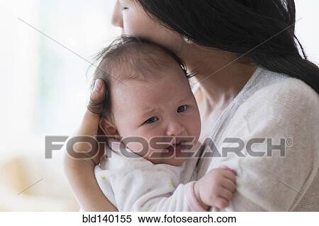 Asian mother comforting crying baby View Large Photo Image Stock Photography - Asian mother comforting crying baby. Fotosearch
