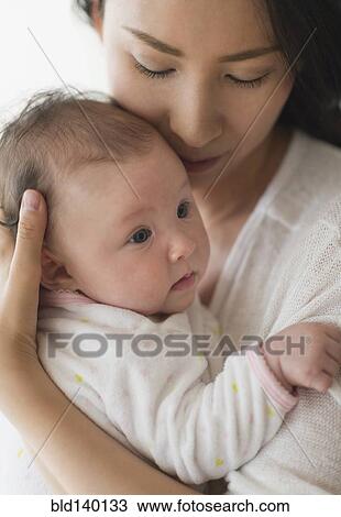 Stock Image - Asian mother holding baby. Fotosearch