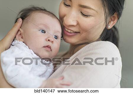 Asian mother holding baby View Large Photo Image Stock Photo - Asian mother holding baby. Fotosearch