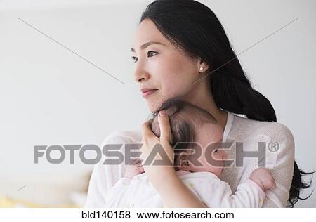 Stock Photo - Asian mother holding baby. Fotosearch