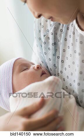 Stock Image - Asian mother holding newborn baby in hospital. Fotosearch