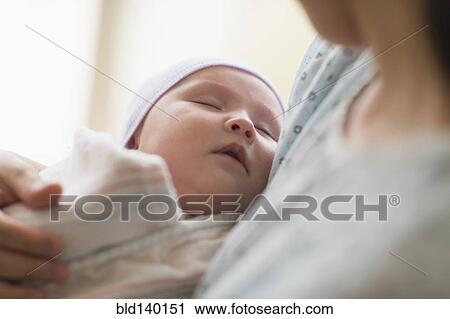 Stock Image - Asian mother holding newborn baby in hospital. Fotosearch