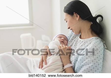 Asian mother holding newborn baby in hospital View Large Photo Image Stock Image - Asian mother holding newborn baby in hospital. Fotosearch
