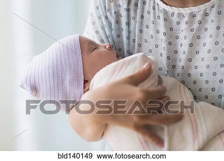 Stock Photo - Asian mother holding newborn baby in hospital. Fotosearch