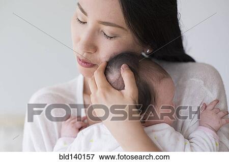 Stock Photo - Asian mother hugging baby. Fotosearch