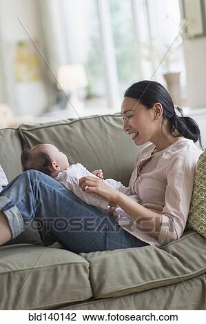 Asian mother playing with baby in living room View Large Photo Image Stock Image - Asian mother playing with baby in living room. Fotosearch