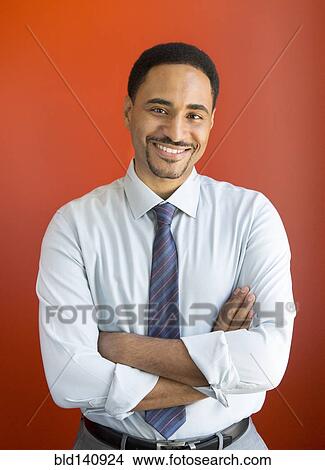 Picture - Black businessman smiling with arms crossed. Fotosearch