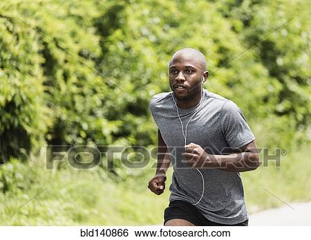 Stock Photograph - Black man running in park. Fotosearch