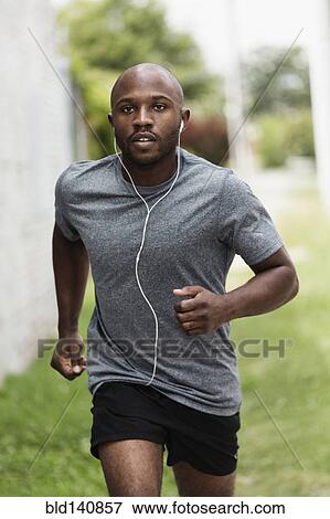 Black man running in urban grass View Large Photo Image Stock Photo - Black man running in urban grass. Fotosearch