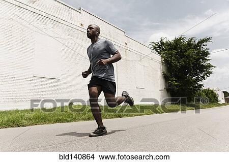 Black man running on city street View Large Photo Image Picture - Black man running on city street. Fotosearch