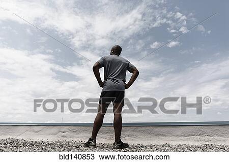 Black runner contemplating landscape View Large Photo Image Stock Image - Black runner contemplating landscape. Fotosearch