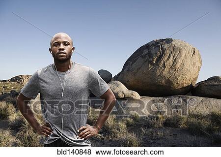 Black runner standing in rocky remote landscape View Large Photo Image Stock Photo - Black runner standing in rocky remote landscape. Fotosearch