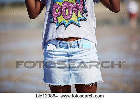 Black teenage girl carrying two cell phones in skirt pockets on beach View Large Photo Image Picture - Black teenage girl carrying two cell phones in skirt pockets on beach. Fotosearch