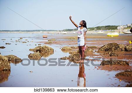 Black teenage girl taking selfie on beach View Large Photo Image Stock Image - Black teenage girl taking selfie on beach. Fotosearch