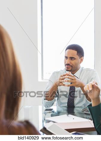Business people listening in meeting View Large Photo Image Stock Photo - Business people listening in meeting. Fotosearch