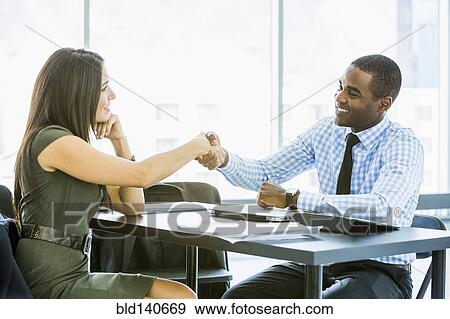 Stock Photo - Business people shaking hands in meeting. Fotosearch