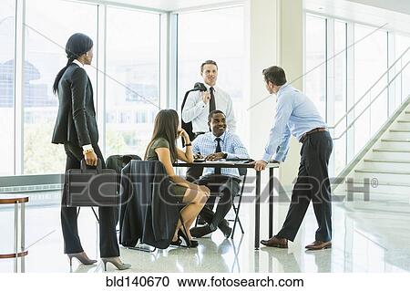 Stock Image - Business people talking in meeting. Fotosearch