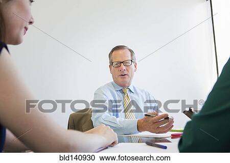 Stock Image - Business people talking in meeting. Fotosearch