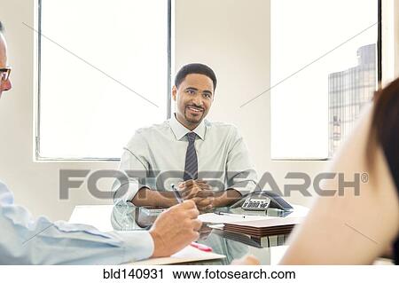 Stock Image - Business people talking in meeting. Fotosearch