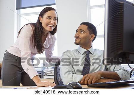 Business people working together at computer in office View Large Photo Image Stock Photo - Business people working together at computer in office. Fotosearch