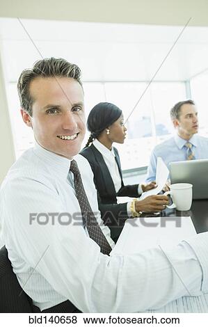 Stock Photo - Businessman smiling in meeting. Fotosearch